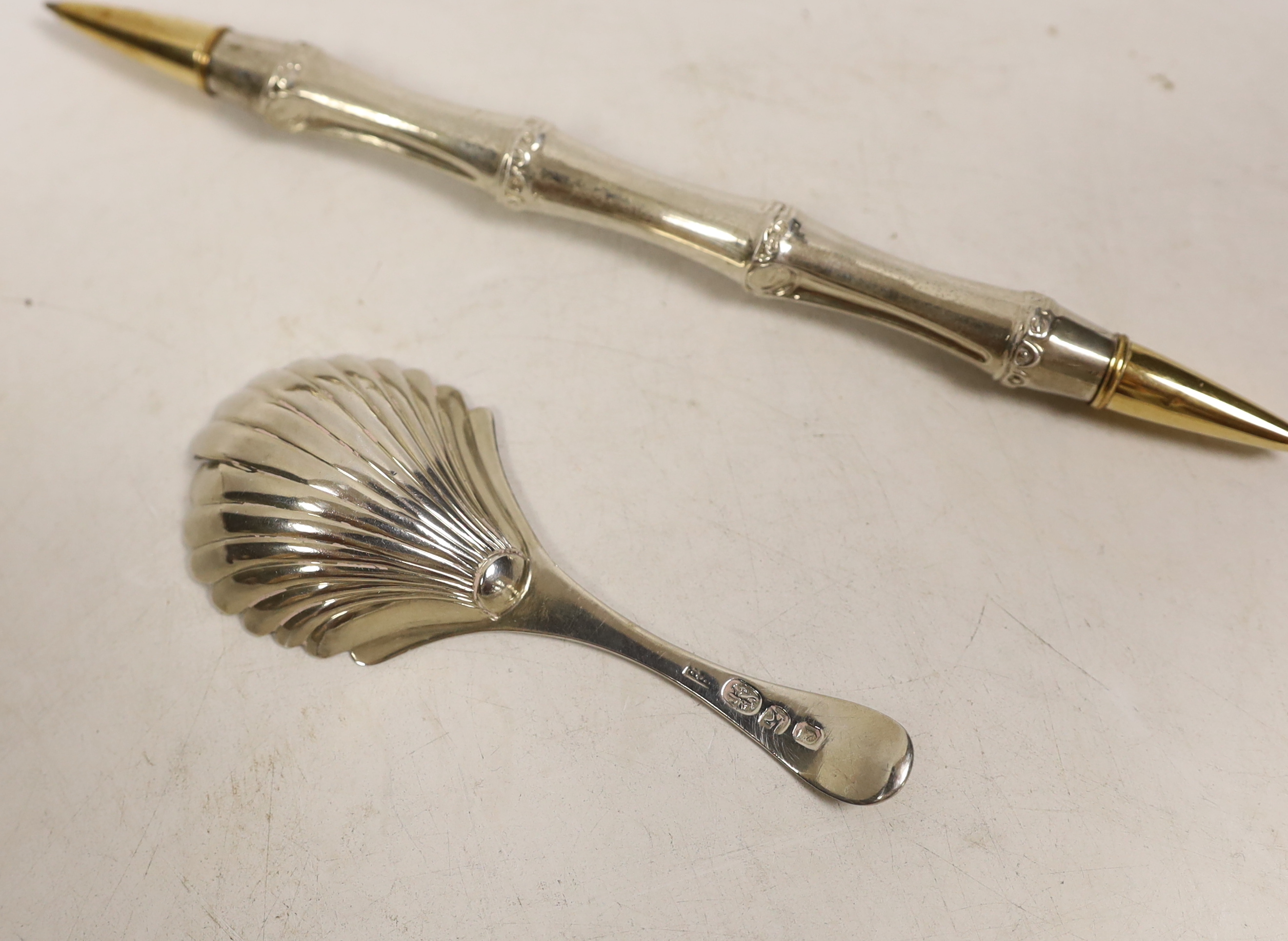 A George III silver bright cut engraved caddy spoon, Walter Brind, London 1785, 91mm, a pair of Georgian silver sugar tongs and two pens.
